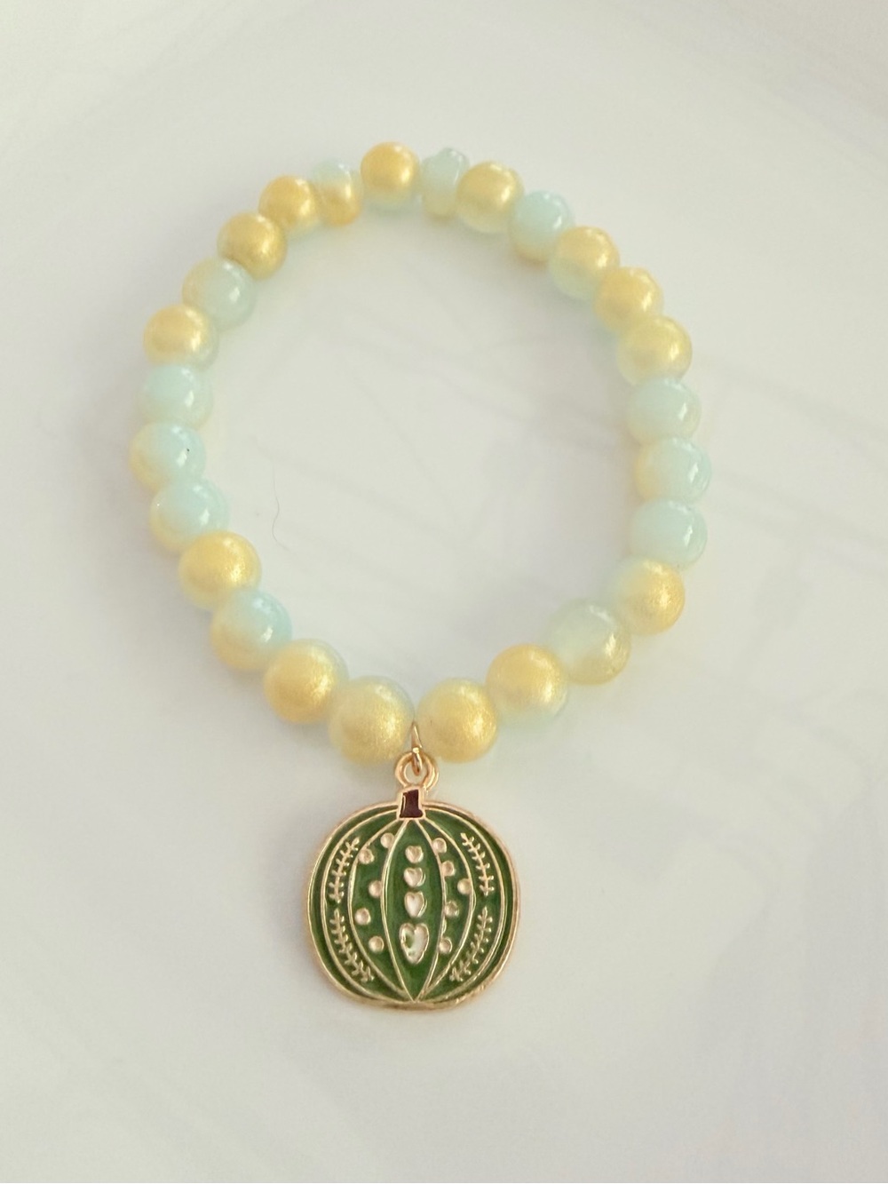 Gold and Light Blue Beaded Bracelet with Green Enamel Pumpkin Pendant